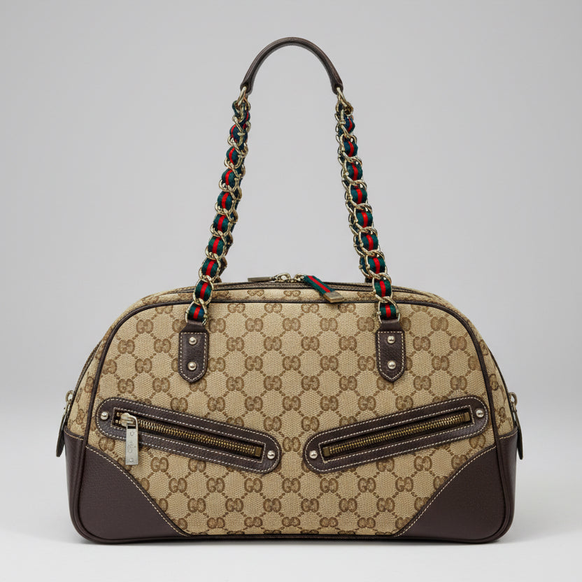 Designer handbag with patterned strap on a colorful fabric background