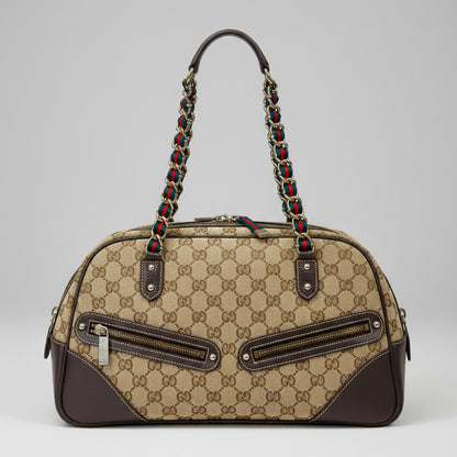 Designer handbag with patterned strap on a colorful fabric background