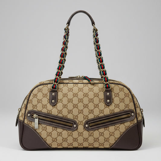 Designer handbag with patterned strap on a colorful fabric background
